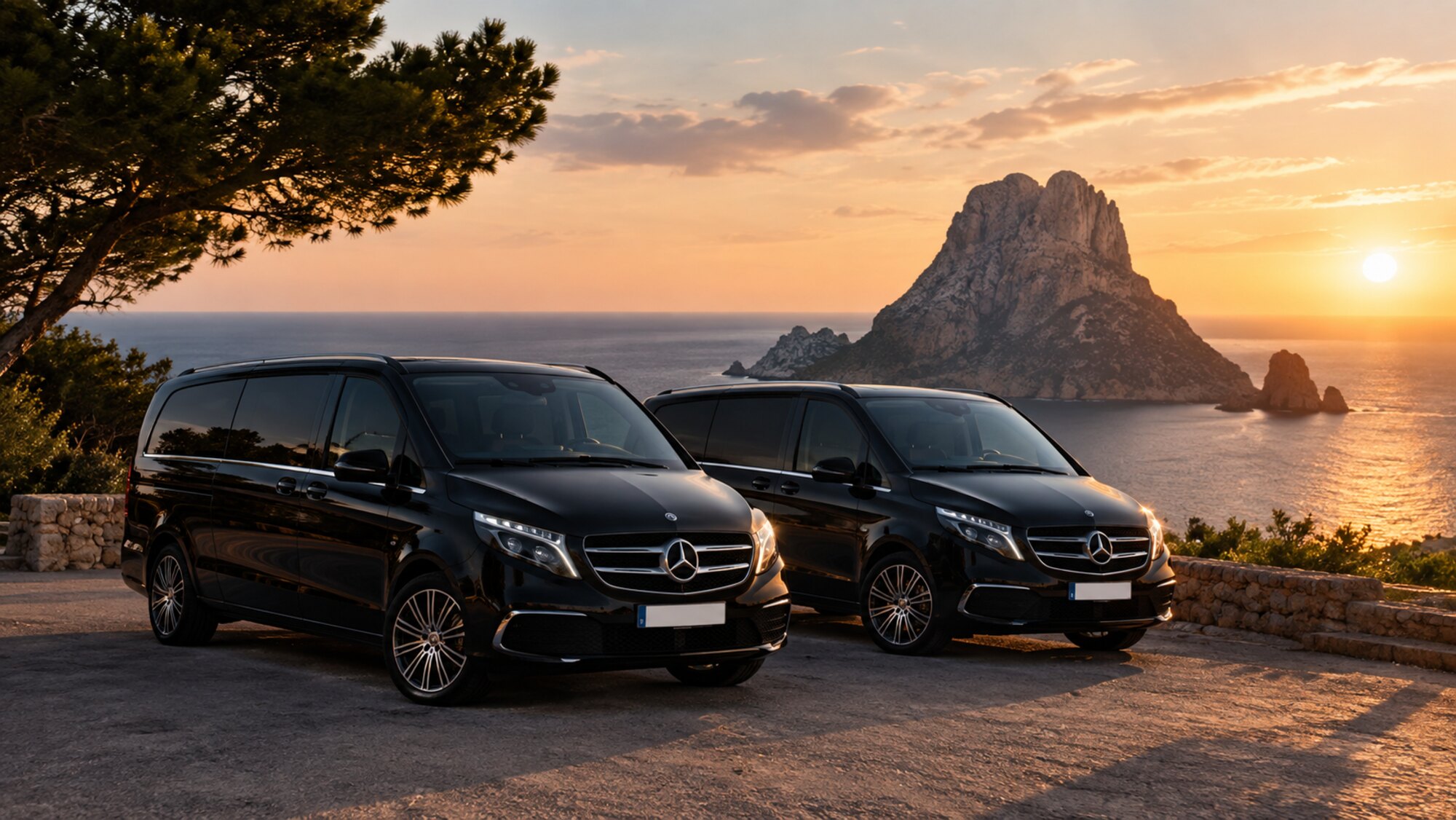 Dos Mercedes V-Class negros de White Transfer Ibiza frente a Es Vedrà al atardecer